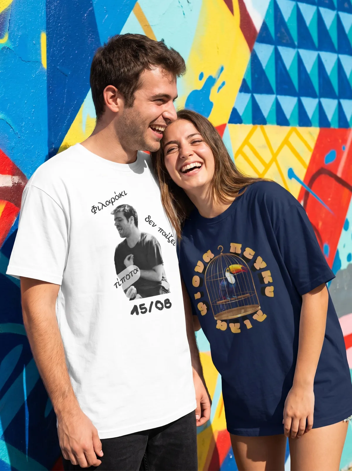 Ζευγάρι με t-shirts Tee Fasi γελάει μπροστά σε πολύχρωμο γκράφιτι τοίχο στην Αθήνα